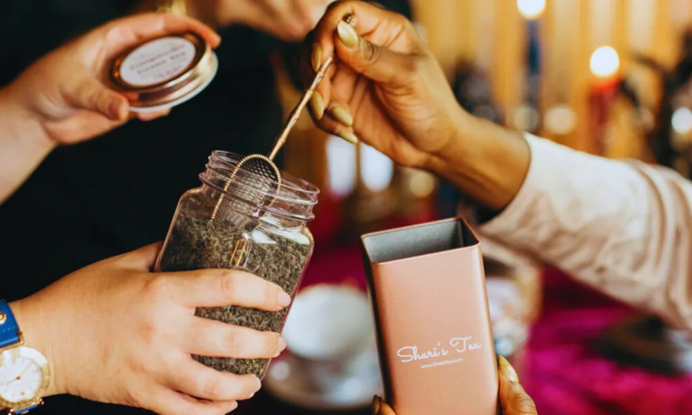 Close-up of guests crafting a custom tea blend with branded packaging