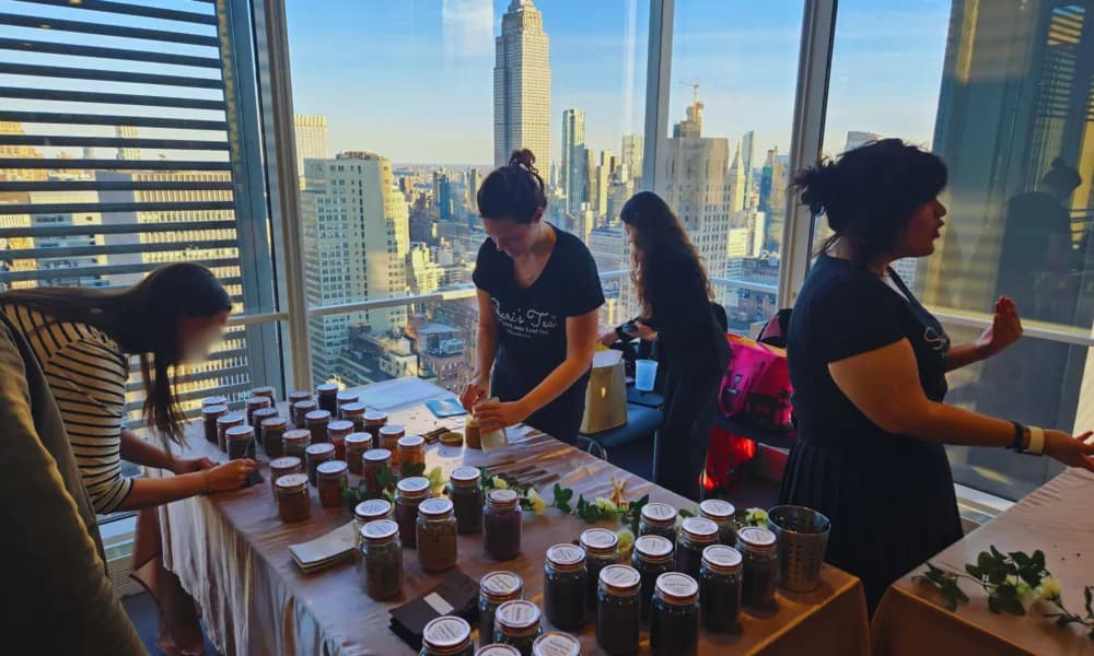 Guests at a custom tea-blending brand activation in a NYC corporate event space overlooking the skyline