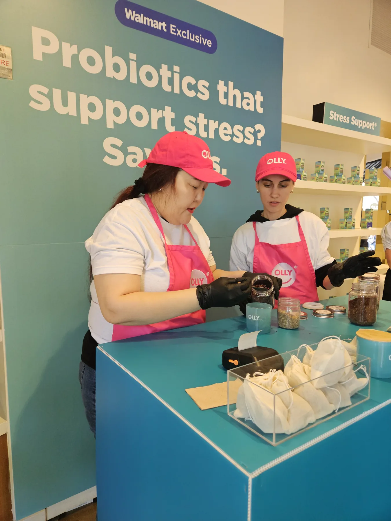 Staff hand-blending custom tea sachets at an OLLY wellness brand activation for Walmart